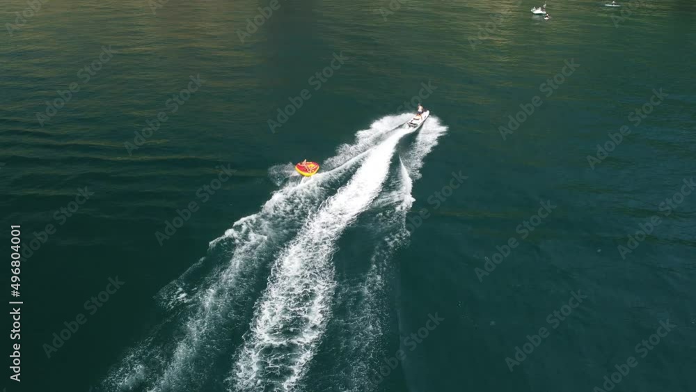custom made wallpaper toronto digitalHappy people are going to swim on an air mattress behind a jet ski. Tourists ride the inflatable watercraft boat. Sea attraction. Jet ski skating people on a large Inflatable raft. Aerial copter view.