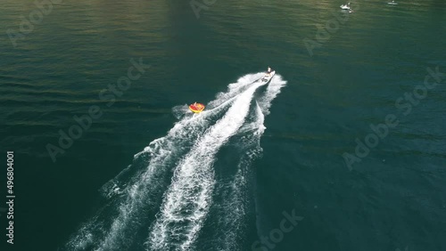 Wallpaper Mural Happy people are going to swim on an air mattress behind a jet ski. Tourists ride the inflatable watercraft boat. Sea attraction. Jet ski skating people on a large Inflatable raft. Aerial copter view. Torontodigital.ca