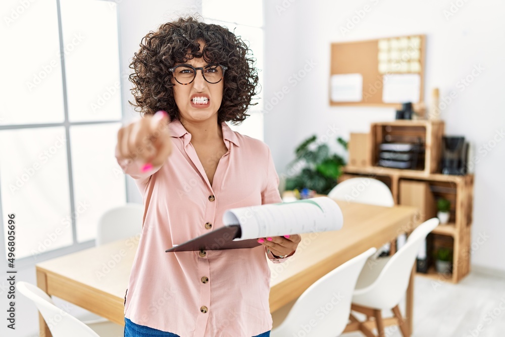 Young middle eastern woman wearing business style at office pointing displeased and frustrated to the camera, angry and furious with you Young middle eastern woman wearing business style at office pointing displeased and frustrated to the camera, angry and furious with you