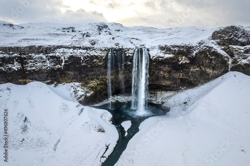 Aerial view of Seljalandsfoss, a beautiful waterfall with snow in wintertime in Iceland.