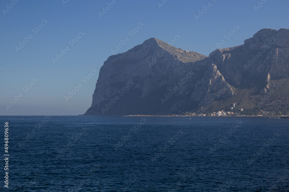 evocative image of sea coast with promontory on the background in Sicily, Italy
