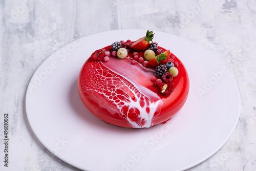 Fotografija Angle shot of a mirror glaze cake decorated with berries.