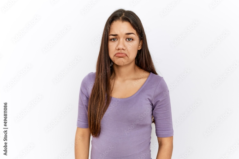 Young brunette woman standing by isolated background depressed and worry for distress, crying angry and afraid. sad expression. Young brunette woman standing by isolated background depressed and worry for distress, crying angry and afraid. sad expression.