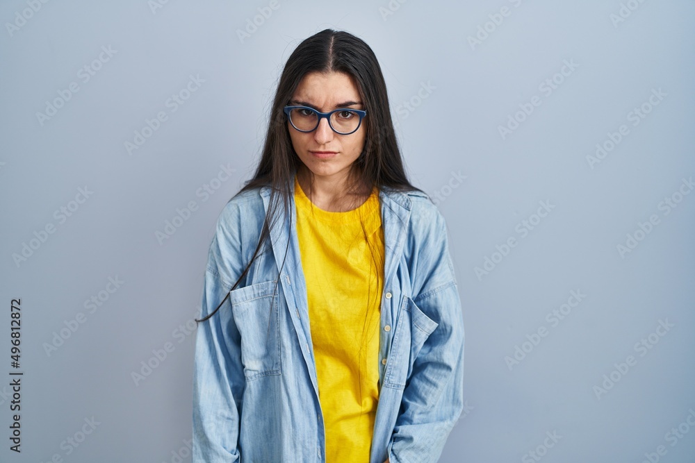 Young hispanic woman standing over blue background depressed and worry for distress, crying angry and afraid. sad expression. Young hispanic woman standing over blue background depressed and worry for distress, crying angry and afraid. sad expression.