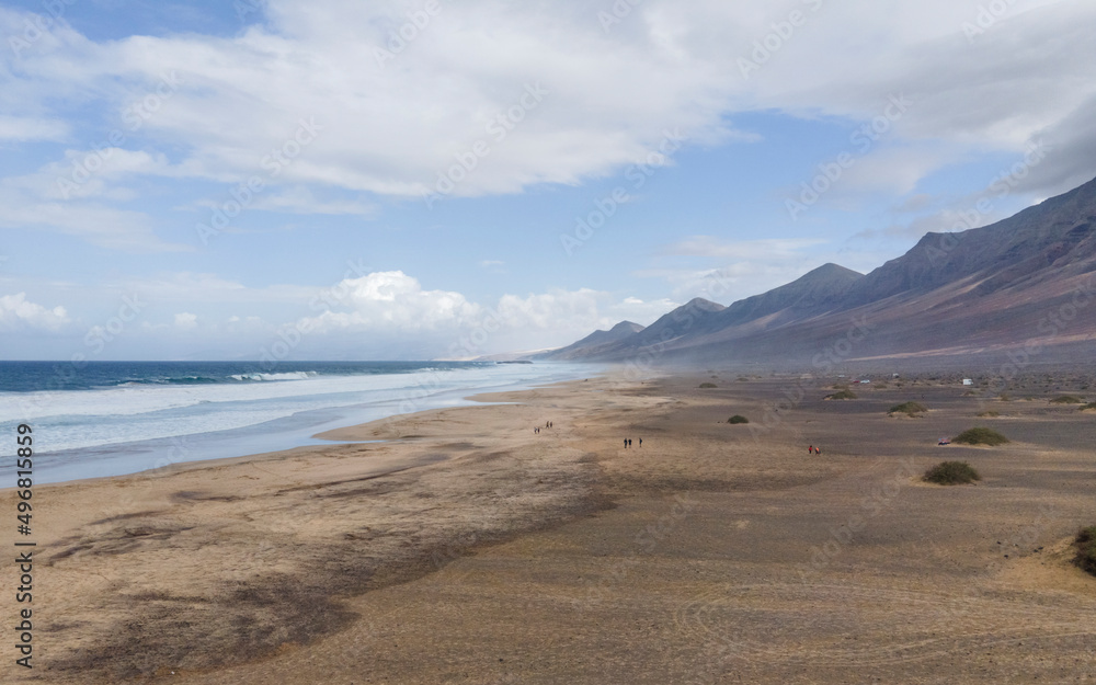 Aerial view of Playa de Cofete, an endless beach along the mountain ridge in Cofete, Fuerteventura, Canary Islands, Spain. Aerial view of Playa de Cofete, an endless beach along the mountain ridge in Cofete, Fuerteventura, Canary Islands, Spain.