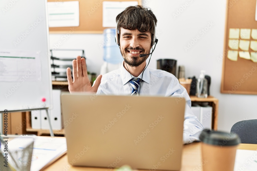 Young hispanic call center agent man having video call working at the office. Young hispanic call center agent man having video call working at the office.