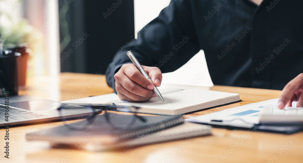 Businessman writing note and calculating business growth graph, analyzing and planning business strategy, financial, marketing and investment at office. Businessman writing note and calculating business growth graph, analyzing and planning business strategy, financial, marketing and investment at office.