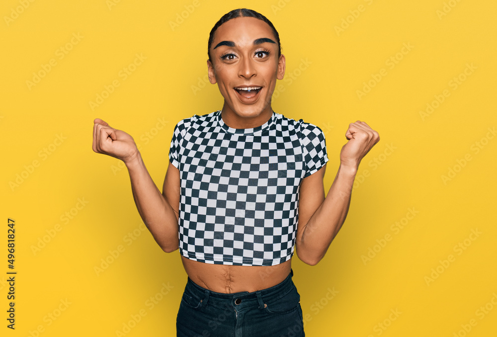 Hispanic transgender man wearing make up and long hair wearing modern clothes celebrating surprised and amazed for success with arms raised and open eyes. winner concept. Hispanic transgender man wearing make up and long hair wearing modern clothes celebrating surprised and amazed for success with arms raised and open eyes. winner concept.