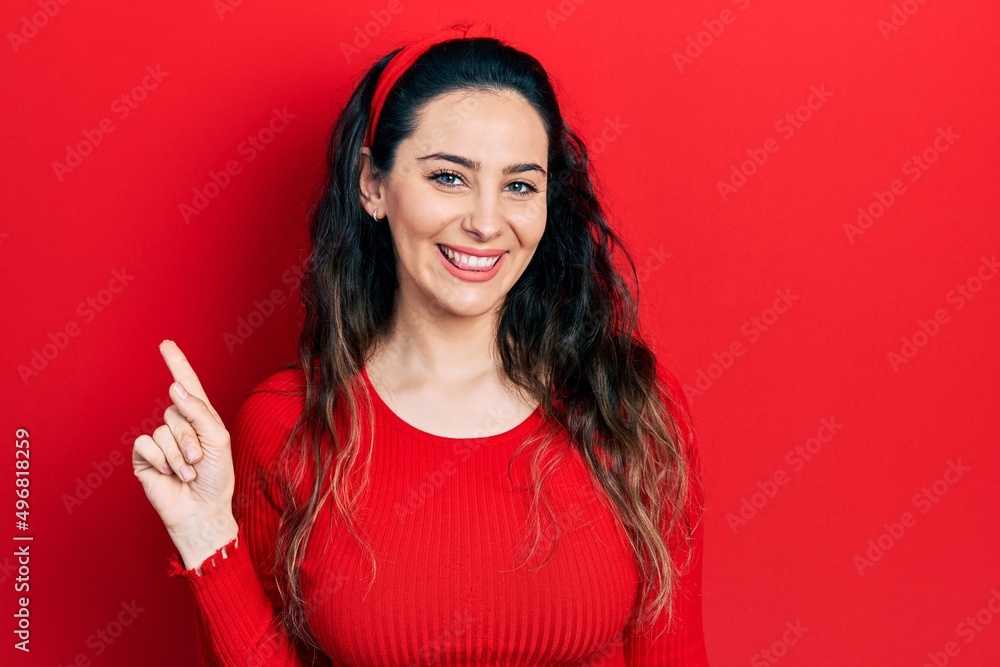 Young hispanic woman wearing casual clothes with a big smile on face, pointing with hand finger to the side looking at the camera. Young hispanic woman wearing casual clothes with a big smile on face, pointing with hand finger to the side looking at the camera.
