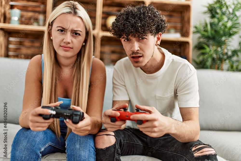 Young couple frustrared playing video game at home. Young couple frustrared playing video game at home.