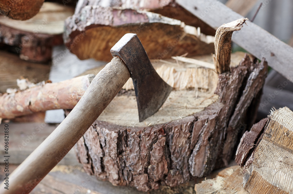 Ax in the stump. Axe for cutting wood. Preparation of firewood for the winter. Selective focus, blurred background