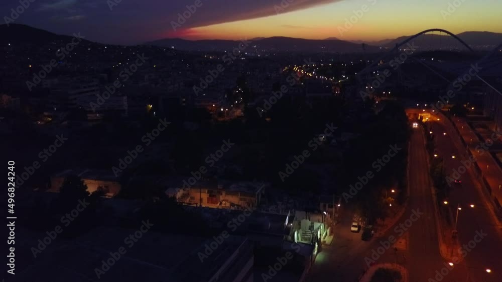 Aerial view at dusk over Athens Greece street with Olympic Stadium silhouetted