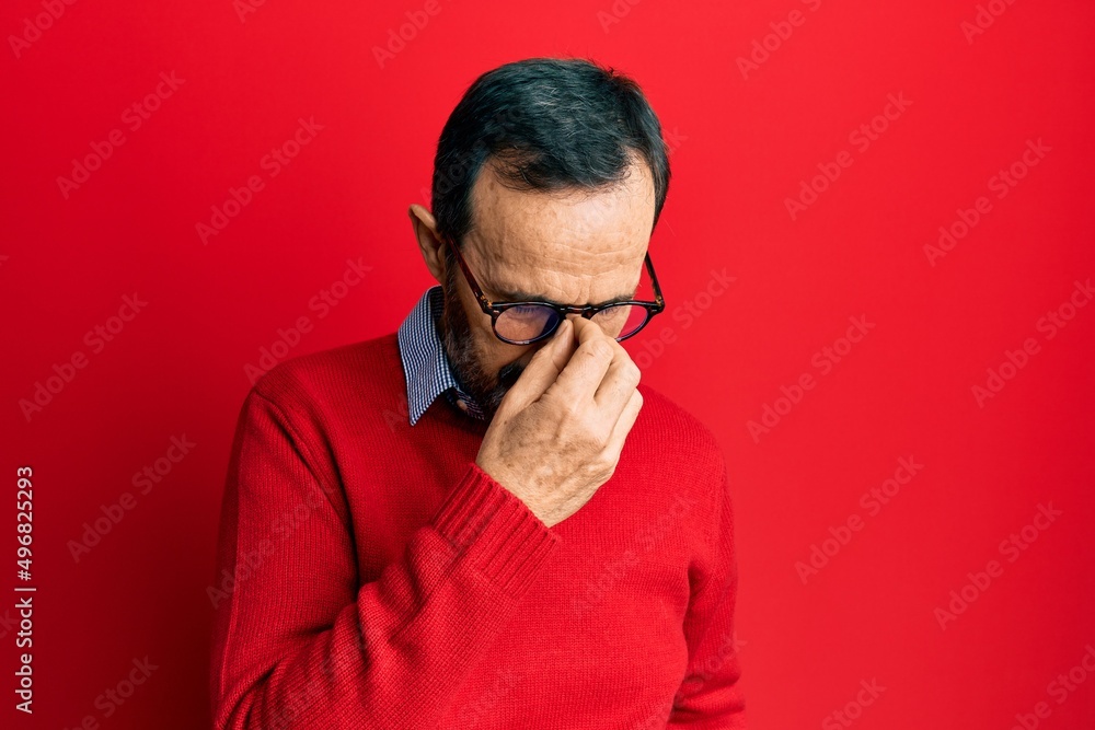 Middle age hispanic man wearing casual clothes and glasses tired rubbing nose and eyes feeling fatigue and headache. stress and frustration concept. Middle age hispanic man wearing casual clothes and glasses tired rubbing nose and eyes feeling fatigue and headache. stress and frustration concept.