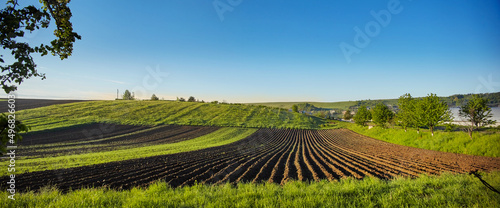 Fototapeta Naklejka Na Ścianę i Meble -  Spring Landscape with Plowed Field on the Background of Beautiful Blue Sky. Ploughed Soil. Agriculture Concept. Copy Space.