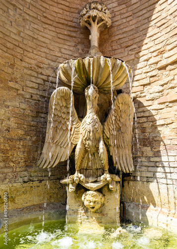 Old water fountain and a  sculpture in Narni, Umbria, Italy photo