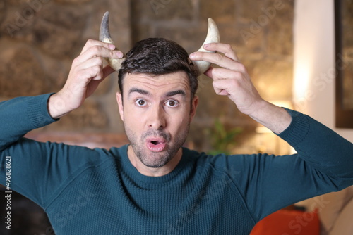 Sad man holding pair of horns