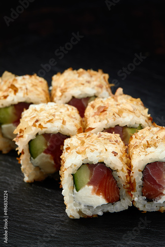 Japanese restaurant menu photo, seafood, national cuisine. Tuna and cheese sushi rolls set served on black plate, food background