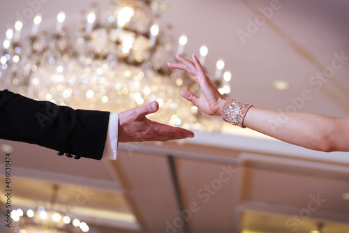 Closeup shot in black and white of the dance couple's hands while dancing a waltz photo