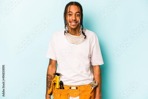 Young mechanic African American man isolated on blue background laughing and having fun.