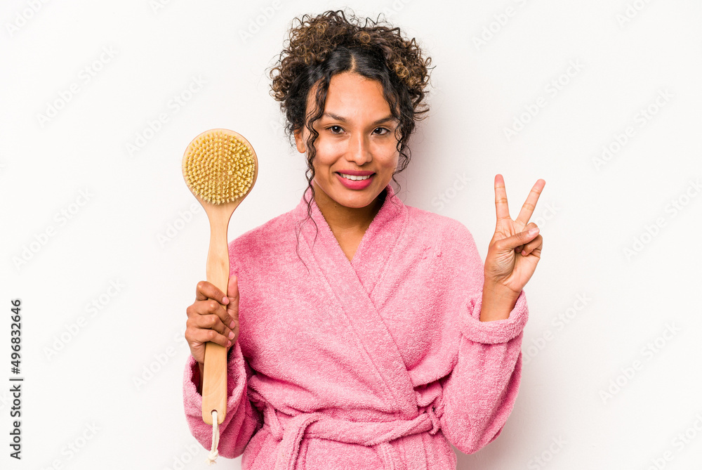 Young hispanic woman holding a back scratcher isolated on white background showing number two with fingers. Young hispanic woman holding a back scratcher isolated on white background showing number two with fingers.