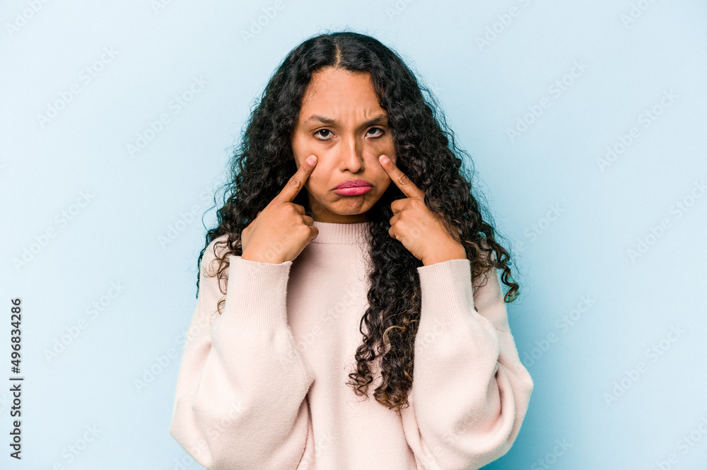 Young hispanic woman isolated on blue background crying, unhappy with something, agony and confusion concept. Young hispanic woman isolated on blue background crying, unhappy with something, agony and confusion concept.