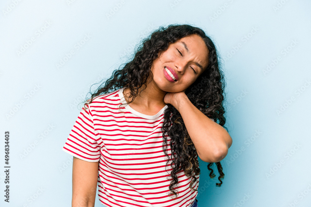 Young hispanic woman isolated on blue background suffering neck pain due to sedentary lifestyle.