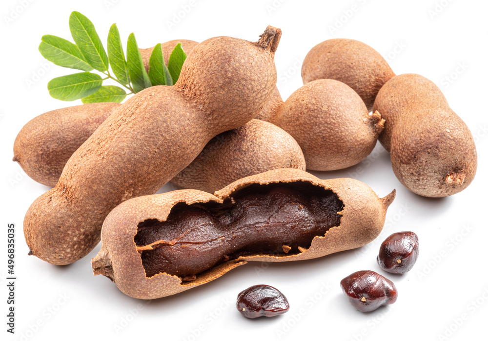 Ripe tamarind fruit, leaves and some tamarind seeds isolated on white