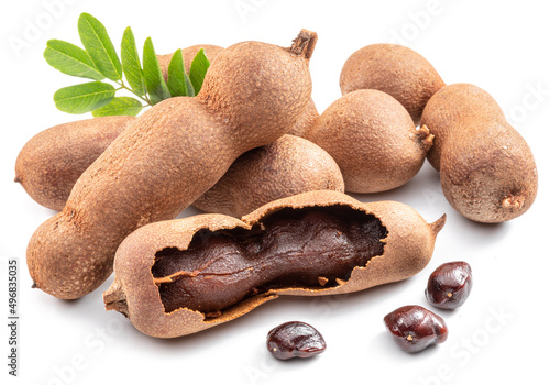Ripe tamarind fruit, leaves and some tamarind seeds isolated on white background. photo