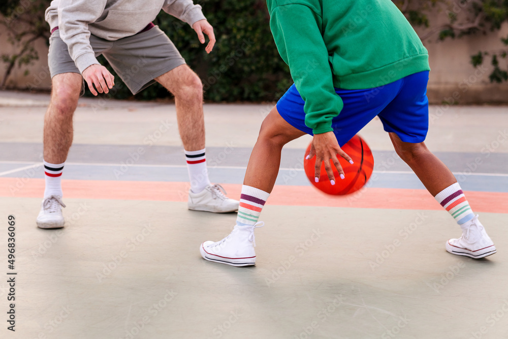 Fototapeta premium legs of two unrecognizable friends playing basket