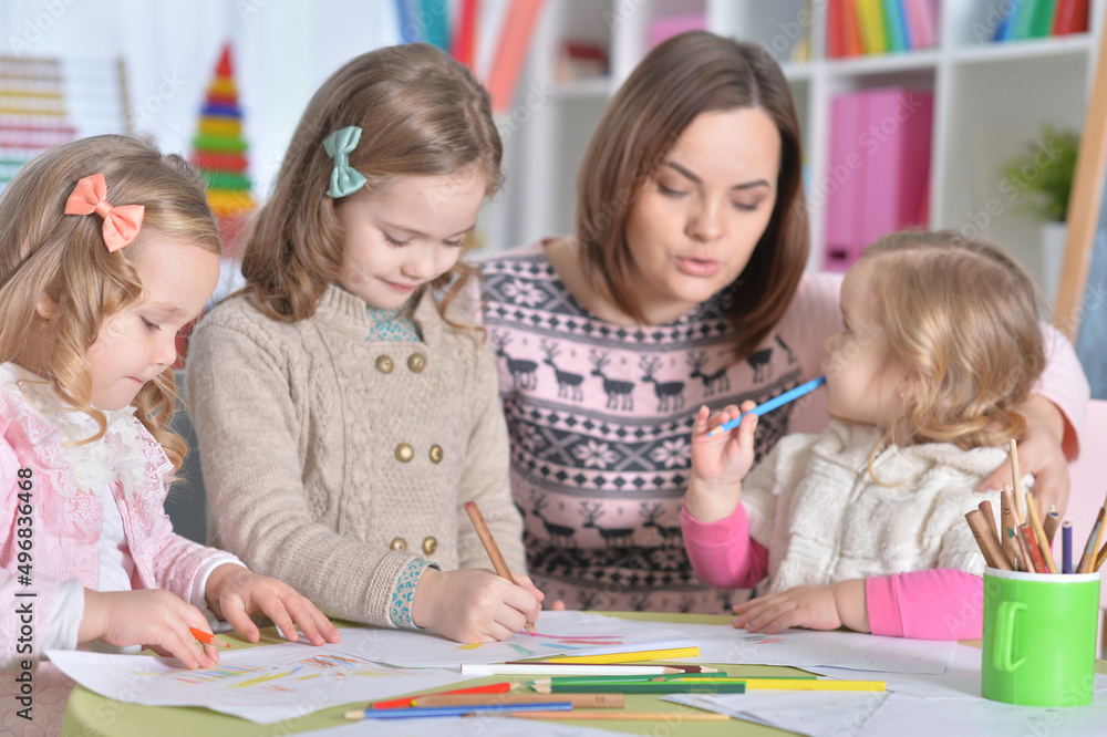 Mother and her three daughters drawing together Mother and her three daughters drawing together