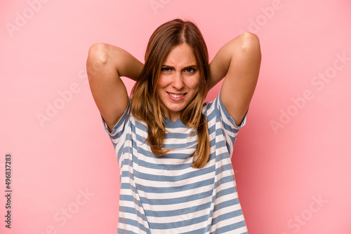 Young caucasian woman isolated on pink background screaming with rage.