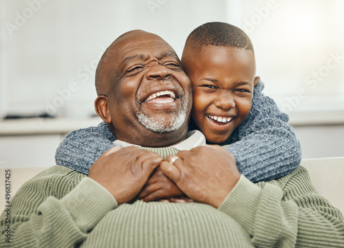 My boy, from my boy. Shot of a grandfather bonding with his young grandson on a sofa at home. photo