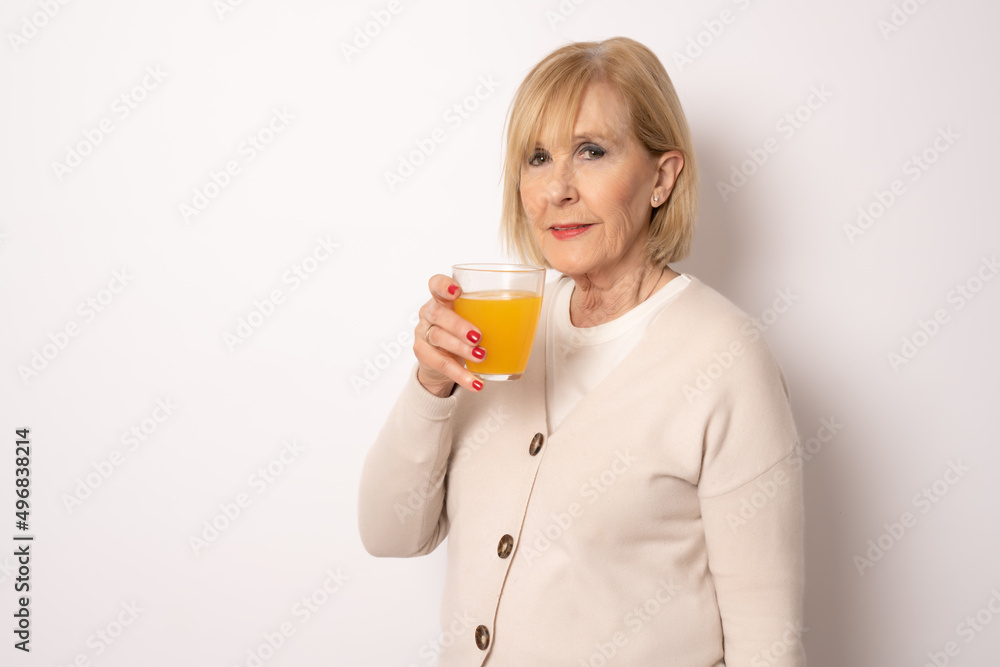 Portrait of senior woman holding orange juice glass Isolated over white Background Portrait of senior woman holding orange juice glass Isolated over white Background