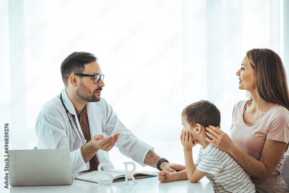 Caring medical doctor examining a little girl in office. Cute child and doctor talking in clinics. Happy male doctor have fun cheer support small 7s boy patient at visit to clinic with mom. Caring medical doctor examining a little girl in office. Cute child and doctor talking in clinics. Happy male doctor have fun cheer support small 7s boy patient at visit to clinic with mom.