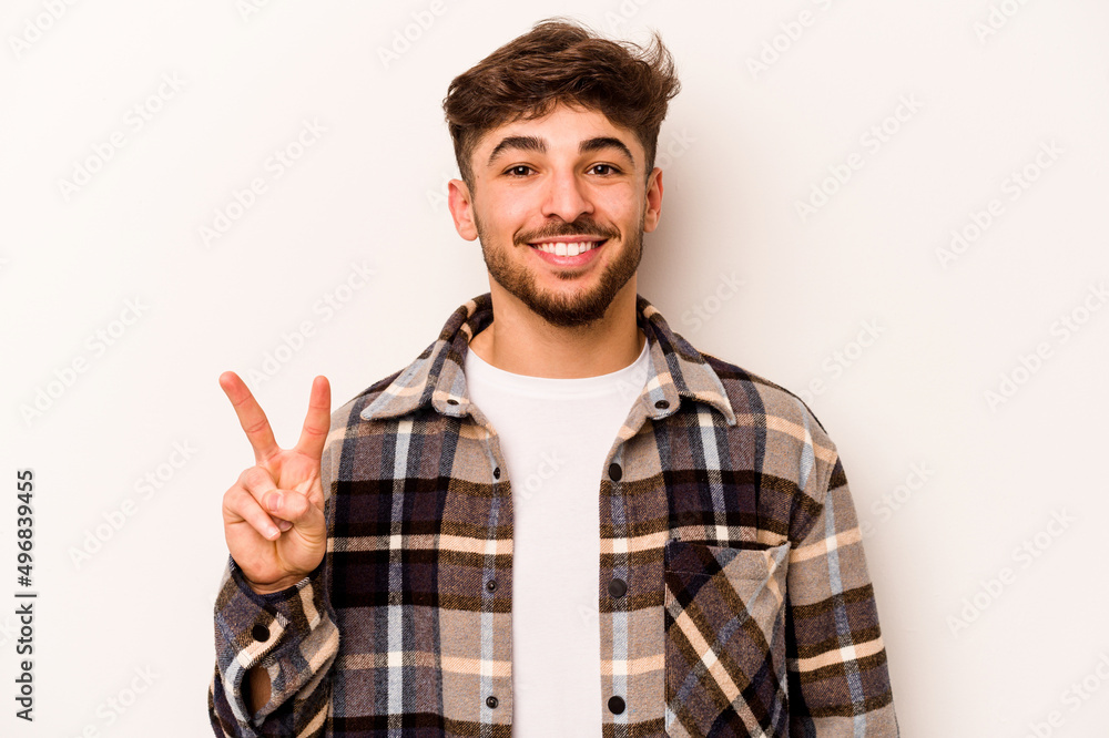 Young hispanic man isolated on white background showing victory sign and smiling broadly. Young hispanic man isolated on white background showing victory sign and smiling broadly.