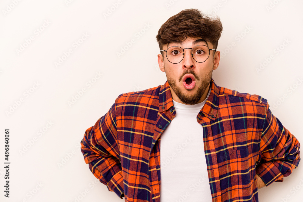 Young hispanic man isolated on white background being shocked because of something she has seen.