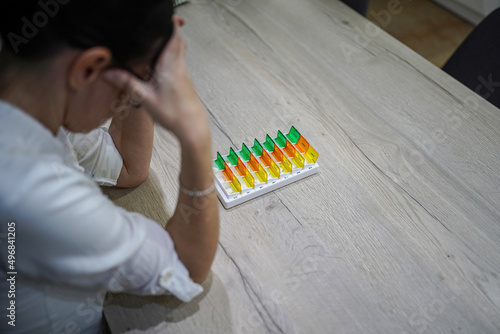 young woman preparing medication at home at the table exhausted, tired