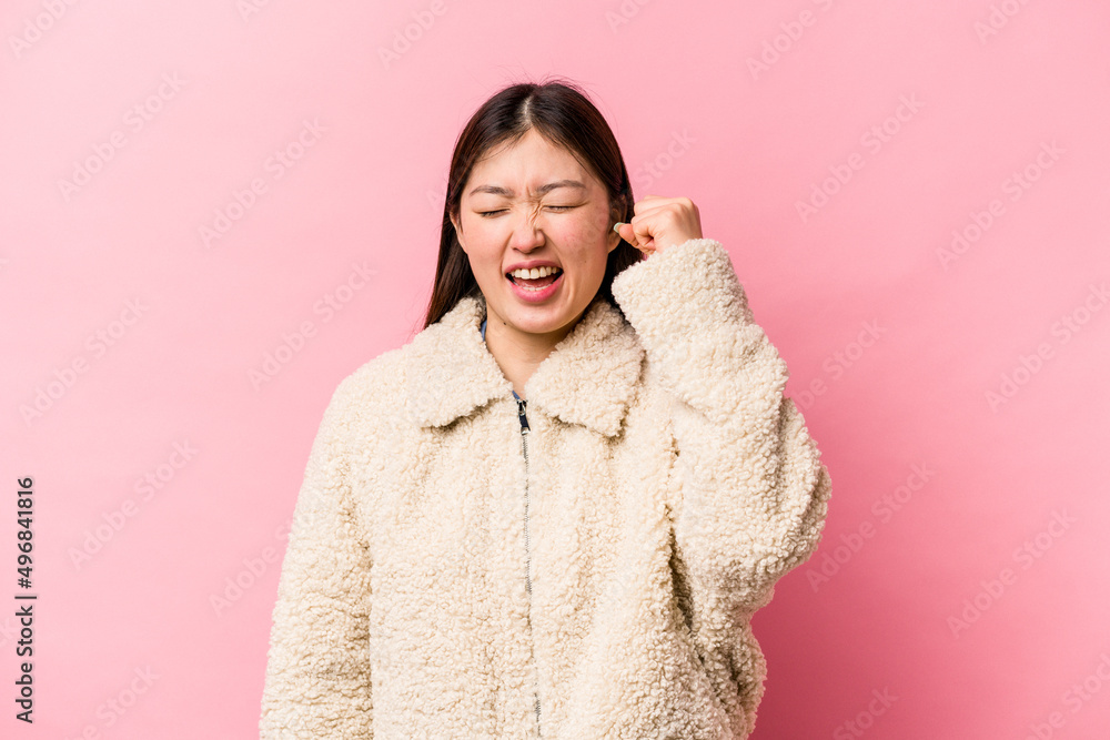 Young Chinese woman isolated on pink background celebrating a victory, passion and enthusiasm, happy expression. Young Chinese woman isolated on pink background celebrating a victory, passion and enthusiasm, happy expression.