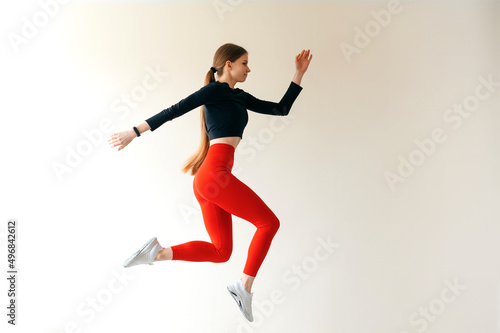 Caucasian sporty woman in sportswear and with ponytail jumping