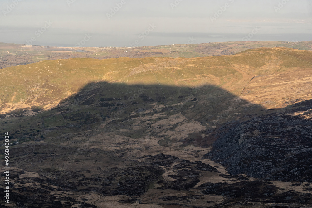Dark shadow of a Welsh mountain on the countryside of Snowdonia North Wales