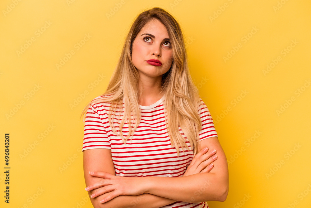 Young caucasian woman isolated on yellow background tired of a repetitive task. Young caucasian woman isolated on yellow background tired of a repetitive task.