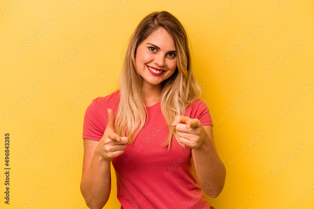 Young caucasian woman isolated on yellow background pointing to front with fingers. Young caucasian woman isolated on yellow background pointing to front with fingers.