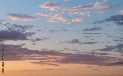 Evening sky with small clouds. Orange sunset. Lavender clouds at sunset