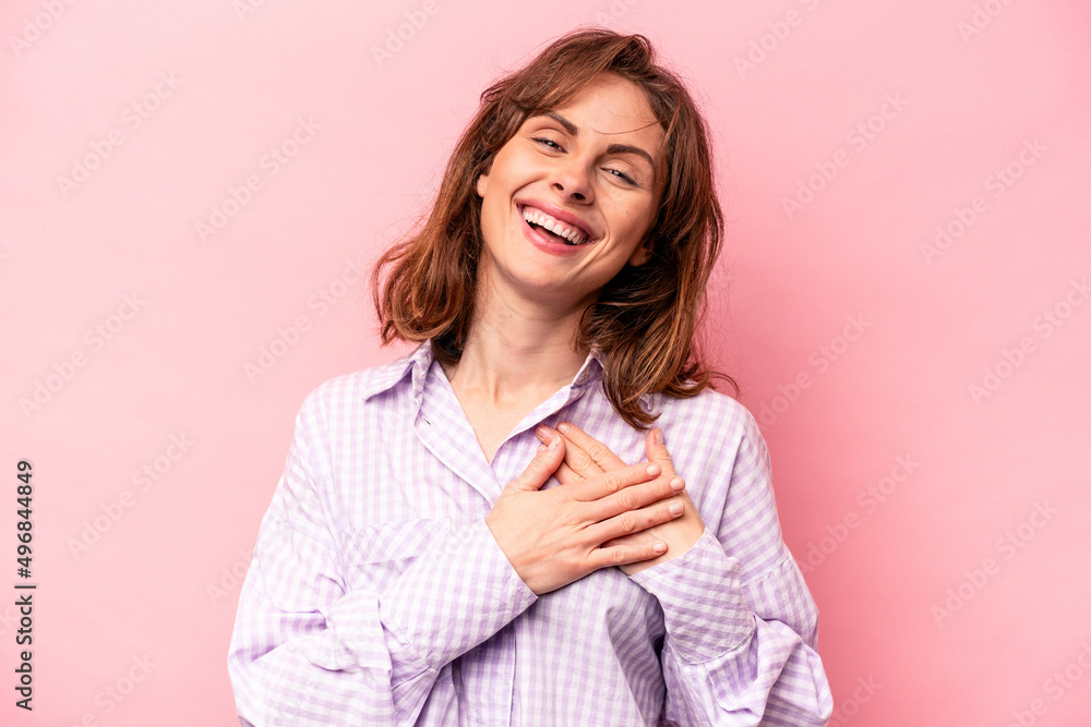Young caucasian woman isolated on pink background has friendly expression, pressing palm to chest. Love concept. Young caucasian woman isolated on pink background has friendly expression, pressing palm to chest. Love concept.
