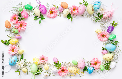 Spring Easter background with multicolored eggs and spring flowers. Top view flat lay background . Greeting card pattern with copy space.
