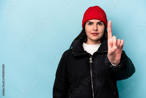 Young caucasian woman isolated on blue background showing number one with finger.