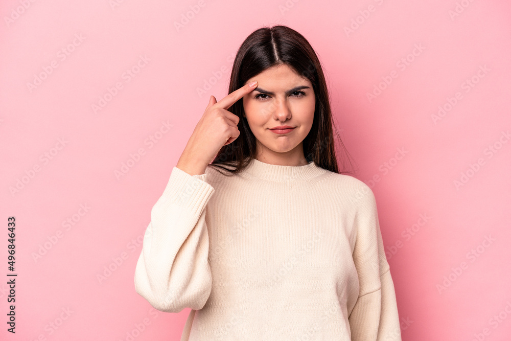 Young caucasian woman isolated on pink background pointing temple with finger, thinking, focused on a task. Young caucasian woman isolated on pink background pointing temple with finger, thinking, focused on a task.