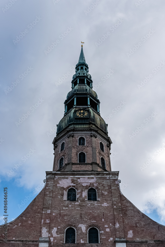 The tower of St. Peter's Church against blue sky with clouds in the Old Town Riga, Latvia