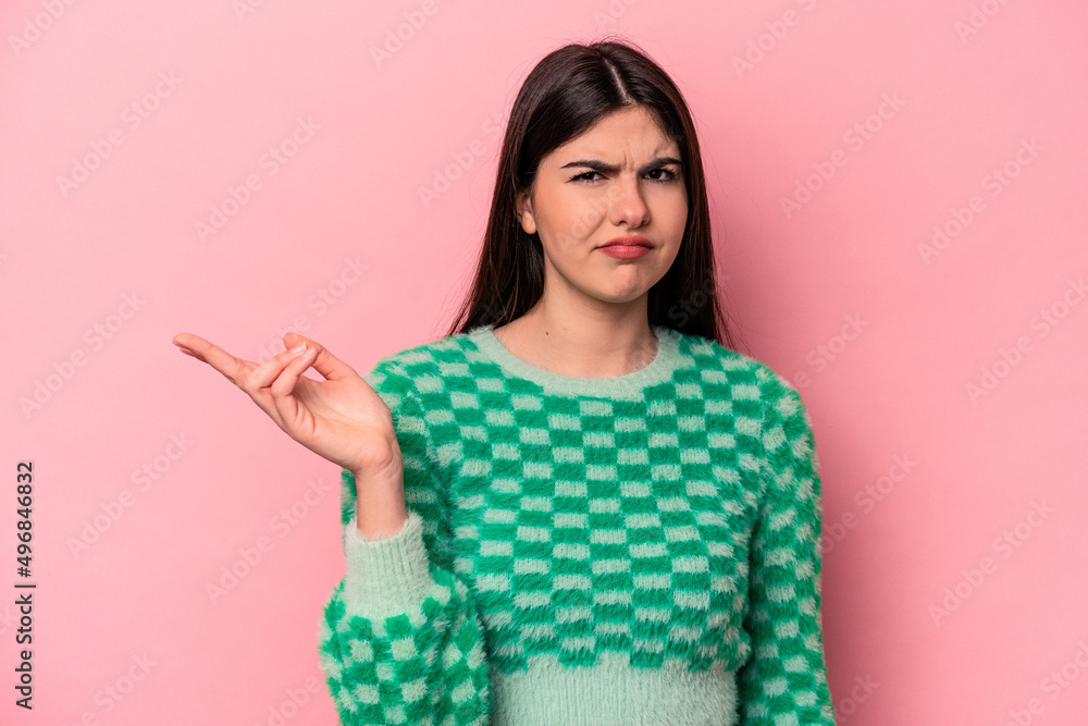 Young caucasian woman isolated on pink background doubting and shrugging shoulders in questioning gesture. Young caucasian woman isolated on pink background doubting and shrugging shoulders in questioning gesture.