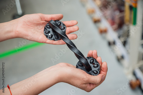 Elegant forged door handle in the hands of a girl. A separate metal black handle in a hardware store